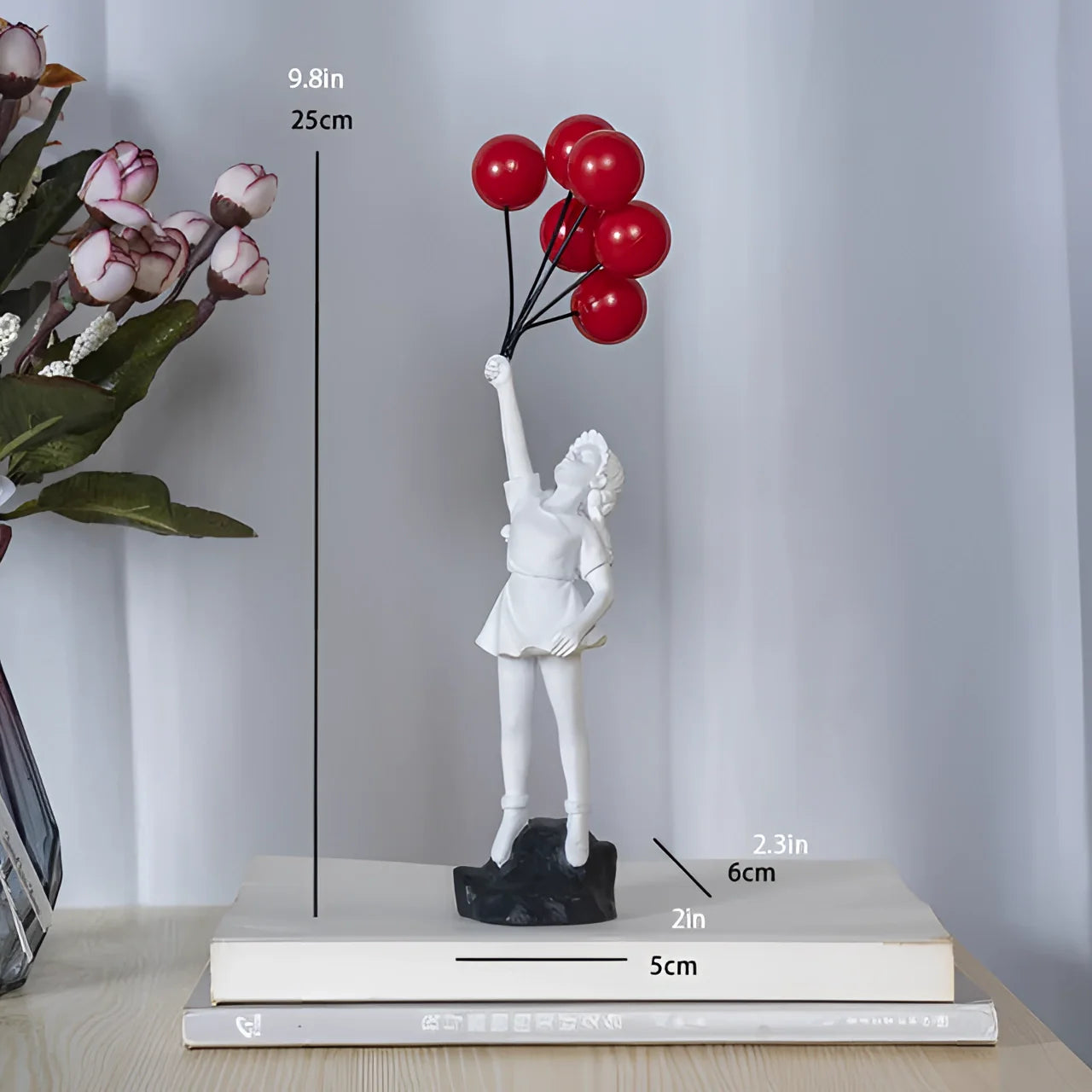 White resin statuette of a girl holding a balloon, featuring elements of urban art. The statuette is styled in a gesture reminiscent of a playful or whimsical pose.