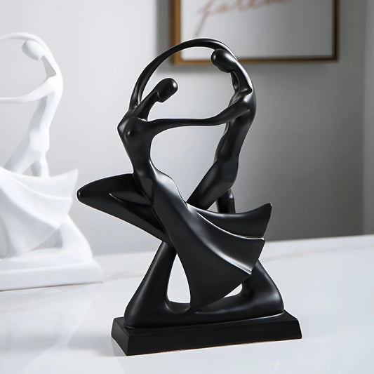 
A modern black resin sculpture depicting an abstract couple in a graceful dance pose, measuring 30cm by 20cm. The artwork is designed with sleek, smooth lines and a metallic finish, presenting a contemporary piece ideal for art decor. The sculpture is displayed on a flat surface, highlighting its elegance and artistic expression.