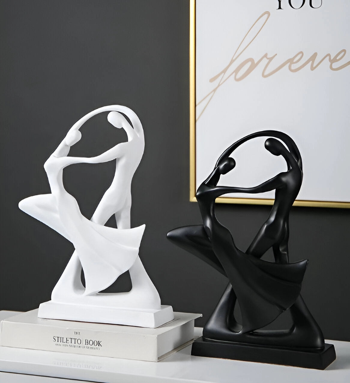 Black resin sculpture depicting an abstract couple in a modern dance pose, highlighting smooth curves and expressive movement, perfect as contemporary art decor.