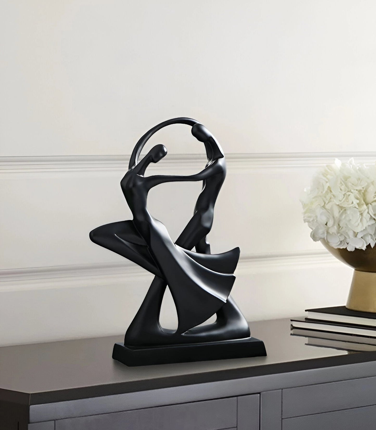 Modern dance black resin sculpture depicting an abstract couple, designed as an art decor piece, displayed on a wooden surface.