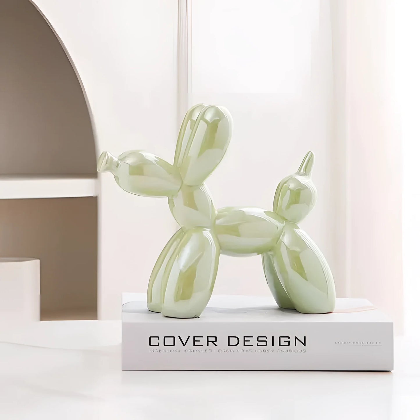 A green metallic balloon dog sculpture placed on a wooden floor in a modern room setting.